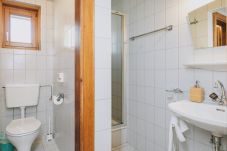 Bathroom in Apartments Haus Altenberger by we rent. Sink, soap, and mirror. Modern bathroom amenities.